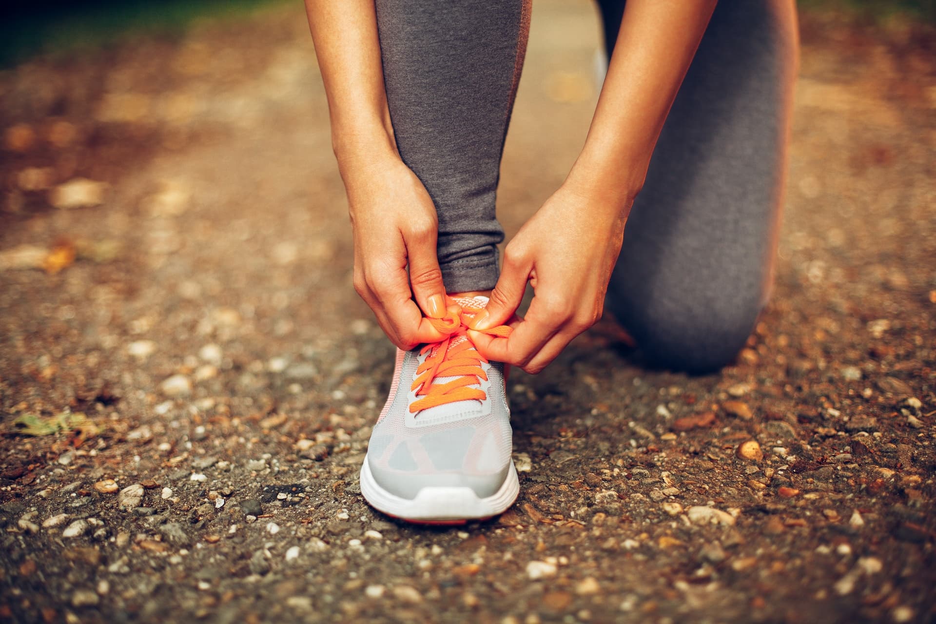 Persona atando los cordones de una zapatilla deportiva